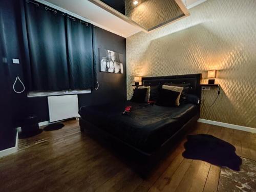 a bedroom with a bed with a black head board at La Demeure d'Ana - Hébergement insolite in Voncq