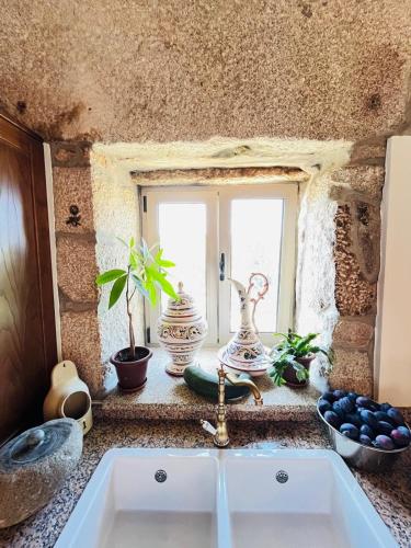 a kitchen counter with a sink and a window at Vila Adelaide in Campos
