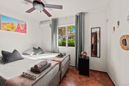 a bedroom with two beds and a ceiling fan at Villa Panlefi - Marbella Estate in Jan Thiel