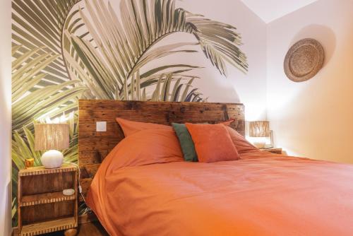 - une chambre avec un lit orange et une grande plante dans l'établissement La Ferme des Tuileries, à Péronnas