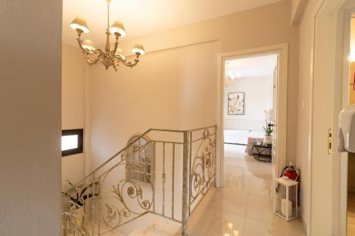 a staircase in a living room with a chandelier at kassandrinos apartments apostolos in Nikiti