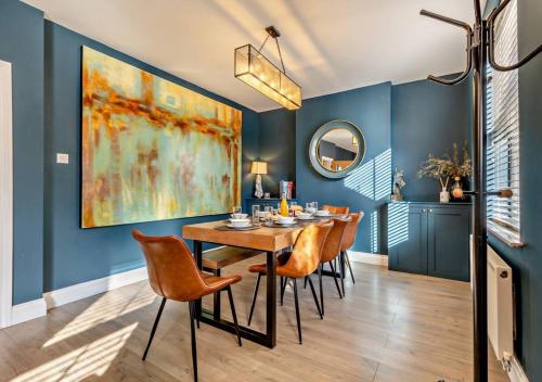 a dining room with blue walls and a table and chairs at Luxury Cromer cottage with hot tub & log burner in Town in Cromer