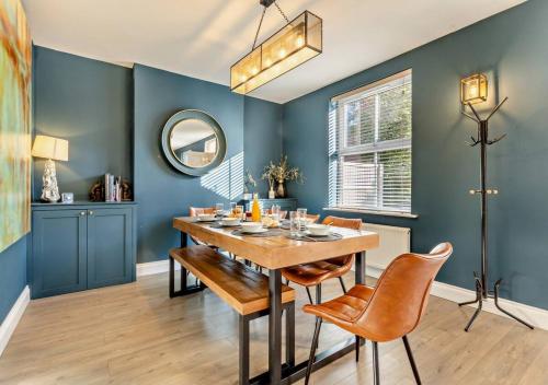 a dining room with blue walls and a table and chairs at Luxury Cromer cottage with hot tub & log burner in Town in Cromer