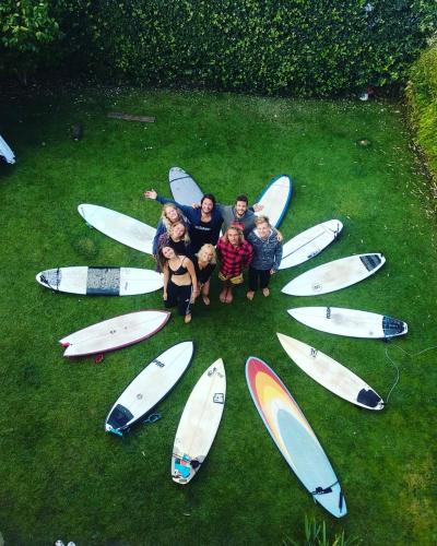 a group of people posing in front of surfboards at Captain's Log House in Baleal