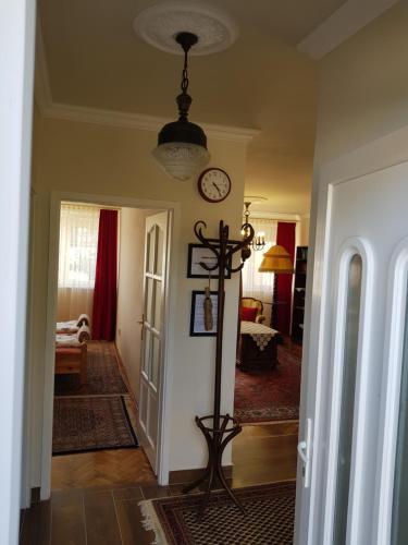a hallway with a clock on the wall and a room at Kussbach apartman in Sárospatak