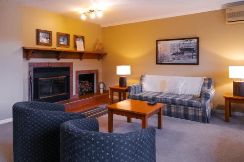 a living room with a couch and chairs and a fireplace at Mont Blanc Hôtel & Condos in Mont-Blanc