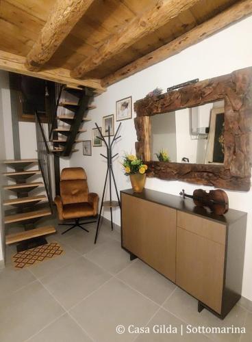 a living room with a mirror and a chair at Casa Gilda in Chioggia