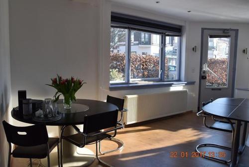 a dining room with a table and chairs and a window at Arnhem Cosy center appartment in Arnhem