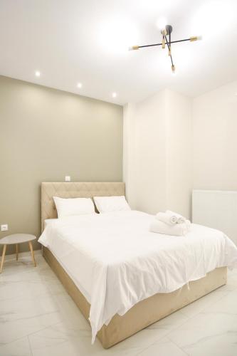 a white bedroom with a large white bed with a ceiling at #1 Ioanna Apartments in Thessaloniki