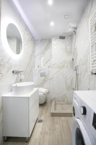 a white bathroom with a sink and a washing machine at #1 Ioanna Apartments in Thessaloniki