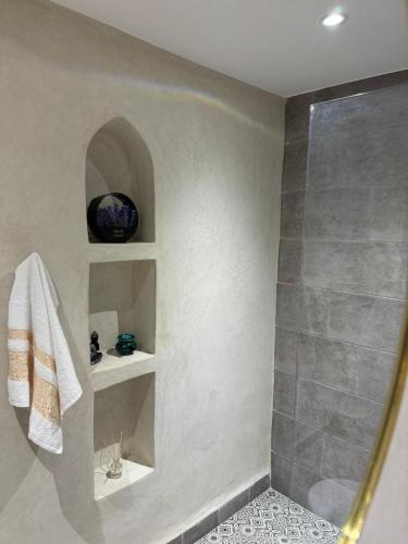 a bathroom with a shower and a towel on a shelf at Cozy, Intimate Villa in Marrakech with Heated Swimming Pool Option in Touggana