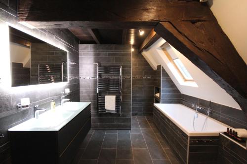 a bathroom with two sinks and a bath tub at Boutique Hotel Steenhof Suites - Adults Only in Leiden