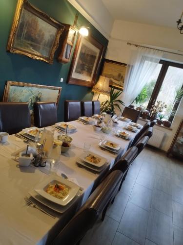 a long table with plates of food on it at Willa Pod Dobrym Humorem in Miedzygorze