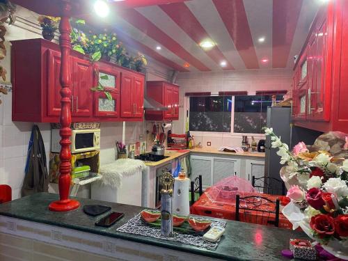 a kitchen with red cabinets and a counter top at Cherchell Algeria Tipaza Apartment Rental in Cherchell