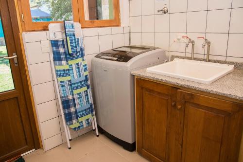 a kitchen with a washing machine and a sink at Sherpa Hostel in San Martín de los Andes