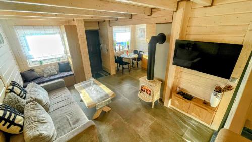 a living room with a couch and a flat screen tv at Domek Tylicka Przystań in Tylicz