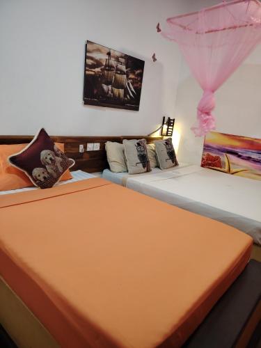 two beds sitting next to each other in a room at Nice View Safari villa in Udawalawe