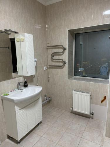 a bathroom with a sink and a shower and a window at 41-40 этаж Отель Bon Dian in Astana