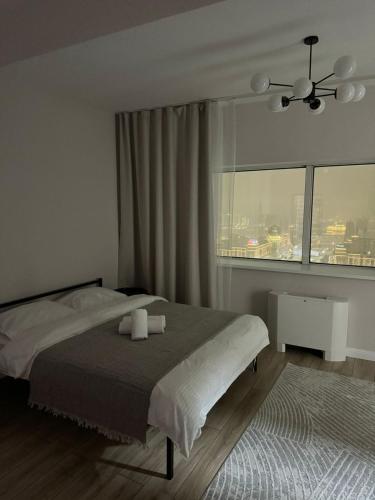 a bedroom with a bed and a large window at 41-40 этаж Отель Bon Dian in Astana