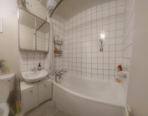 a bathroom with a sink and a tub and a toilet at Centrel to london single bed room quiet home with host and breakfast in London