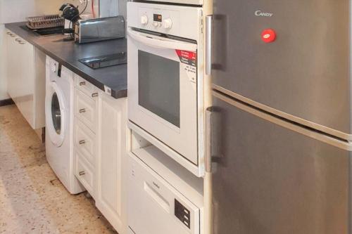 La cuisine est équipée d'un réfrigérateur en acier inoxydable et d'un lave-vaisselle. dans l'établissement Appartement charmant à La Grande-Motte de 37m² avec jardin, à La Grande Motte