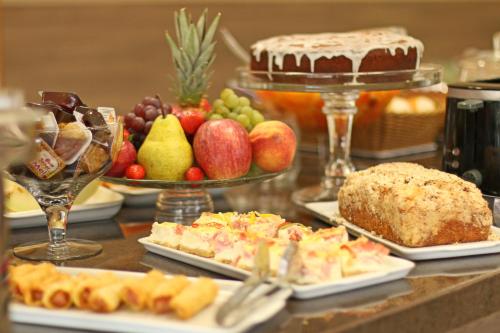 a table topped with lots of different types of food at Ville House Hotel Canoas in Canoas