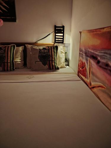 a bed in a room with pillows and a painting at Nice View Safari villa in Udawalawe