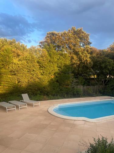 une piscine avec deux chaises longues à côté dans l'établissement La maison du bon remède, à Mazan