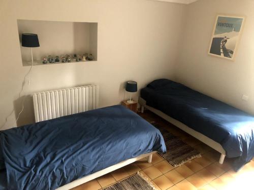 - une chambre avec 2 lits avec des draps bleus dans l'établissement La maison du bon remède, à Mazan