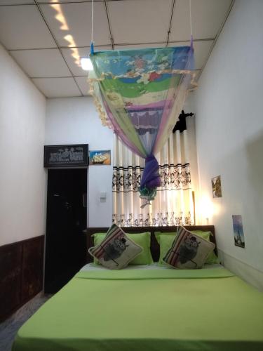 a room with a green bed with a canopy at Nice View Safari villa in Udawalawe