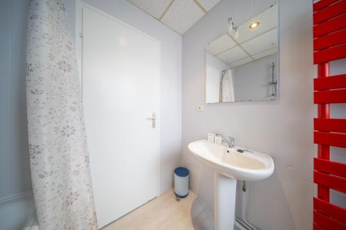 une salle de bain blanche avec un lavabo et un miroir dans l'établissement Very nice apartment - downtown Mulhouse Le 42, à Mulhouse