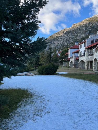 a river with snow on the ground next to houses at Delphi Gorge-view Chalet, Arachova in Arachova