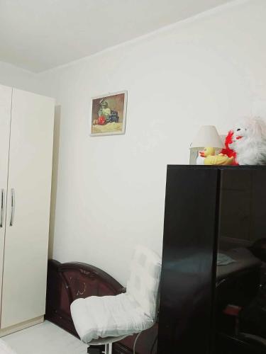 a room with a black cabinet and a white chair at Stairway to Heaven in Shkodër