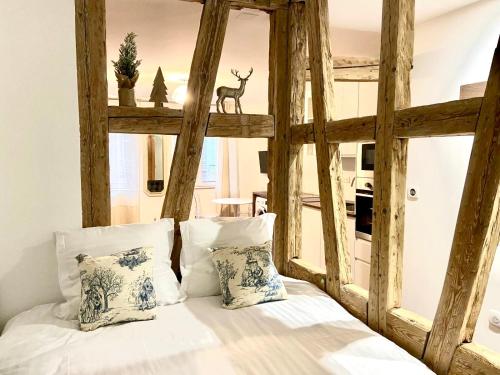 une chambre avec un lit avec des draps blancs et des oreillers dans l'établissement Studio Cathédrale, à Strasbourg