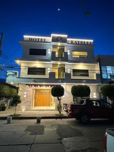a hotel with a car parked in front of it at Hotel Fratelli in Aguascalientes