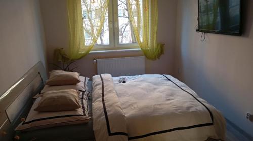 a bed in a bedroom with two pillows and a window at Mieszkanie niedaleko centrum in Gdańsk
