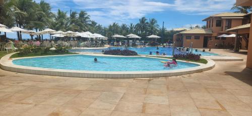 a group of people in a pool at a resort at Flat Guarajuba Summer House - Bahia in Guarajuba