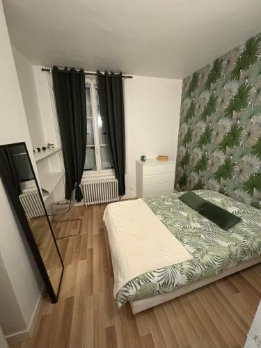 - une chambre dotée d'un lit avec une couverture verte et blanche dans l'établissement Maison de ville, à Beauvais