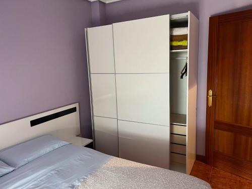 a bedroom with a bed and a large white cabinet at ApartamentoDJ in Suances