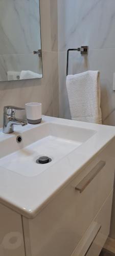 ein Badezimmer mit einem weißen Waschbecken und einem Spiegel in der Unterkunft Casa Mirador in Alcalá