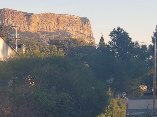 a mountain in the background with trees and a building at Appartement spacieux T3 neuf in Cassis