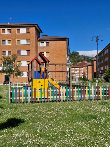 a playground in a park with a colorful fence at Valle del Nalon in San Martín del Rey Aurelio