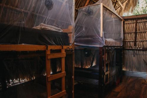 a room with two bunk beds with nets on them at Casa Austera in El Paredón Buena Vista