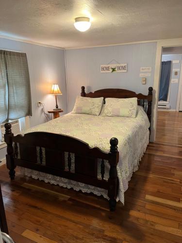 a bedroom with a large bed with a wooden floor at Cochran Farm House in Bryson City