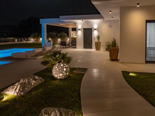 a villa with a swimming pool at night at Ocean Pearl Sea View in Faliraki