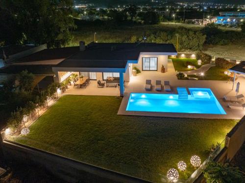 a house with a swimming pool in the yard at night at Ocean Pearl Sea View in Faliraki