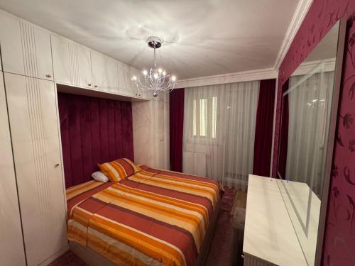 a bedroom with a bed and a chandelier at Prishtina Vibes Apartment in Pristina