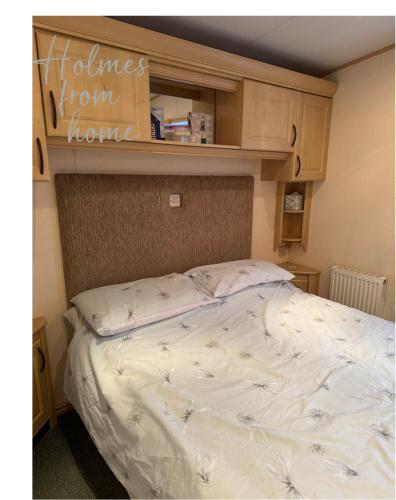 a bed in a room with a shelf above it at Holmes from Home - 106 Sunrise Southview in Winthorpe