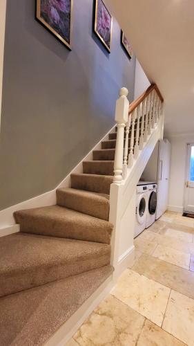 a staircase in a house with a laundry room at St Michaels Town House - Elegant and Large Holiday Home in the Heart of Gloucester in Gloucester