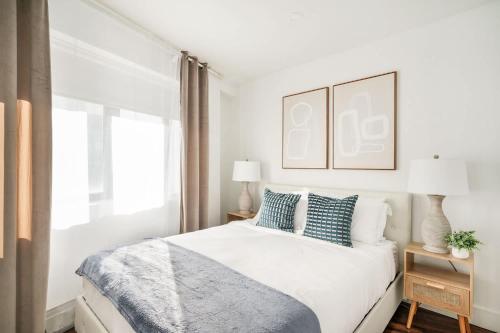 a white bedroom with a bed with blue pillows at 809-5A Gorgeous New 1BR Heart of Midtown in New York